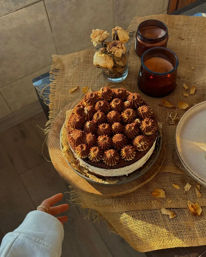 Torta redonda decorada con copos de crema de chocolate.