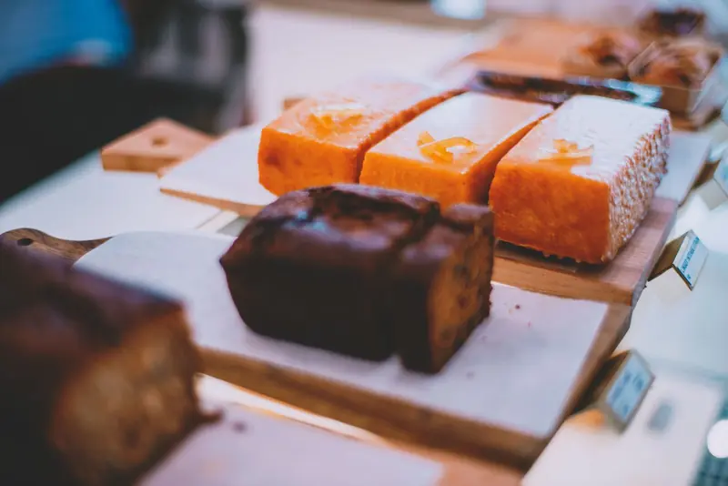 Porciones de budín de naranja con glaseado y un budín de chocolate.
